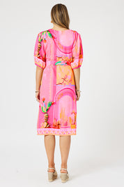 A model wearing the Tulum Dress in colour Pink (Pink), from the back