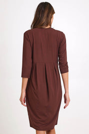 Model Madelinec wearing size 10 of the Box Pleat Dress – Choc in colour Choc, from the back