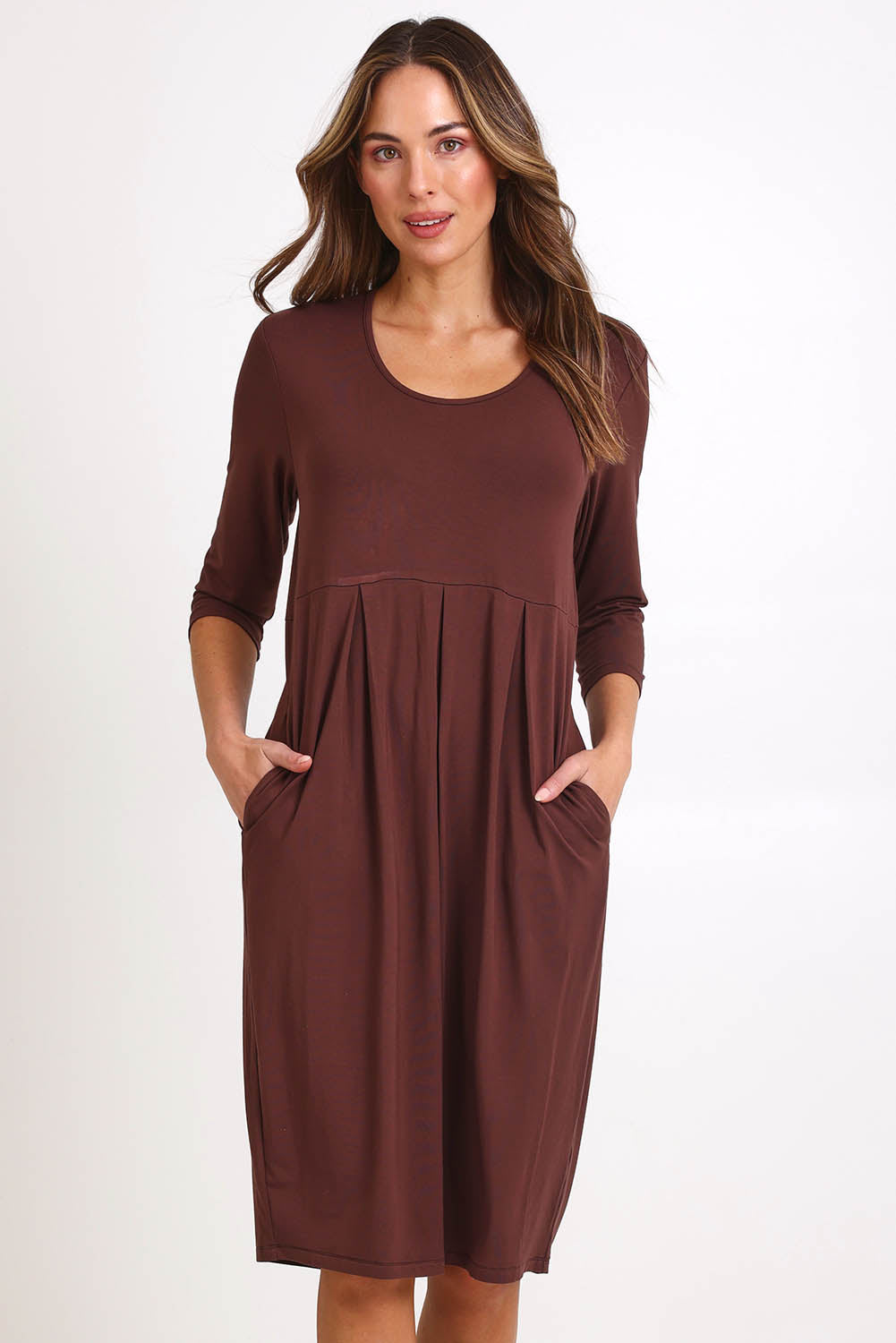 Model Madelinec wearing size 10 of the Box Pleat Dress – Choc in colour Choc, from the front
