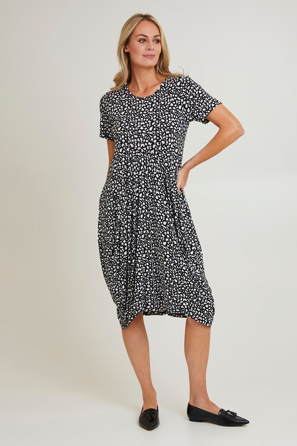 Model Grace wearing size 10 of the Cap Sleeve Bounce Dress in colour Blkwhite (Black), from the front, showing the whole outfit
