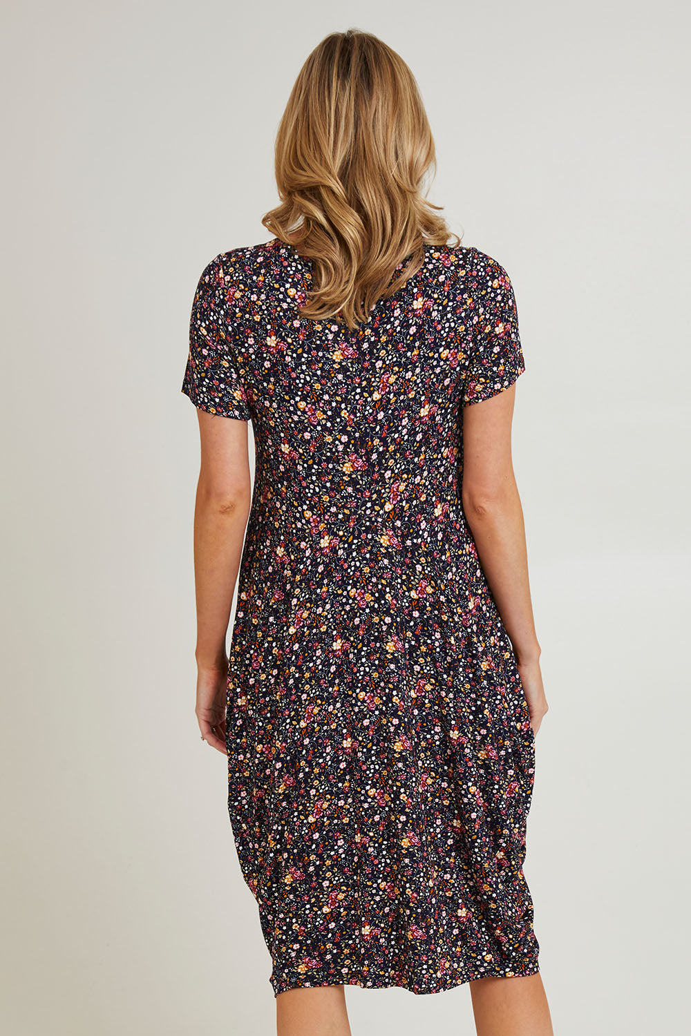 Model Grace wearing size 10 of the Cap Sleeve Bounce Dress in colour Floral (Black), from the back