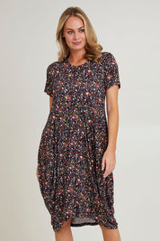 Model Grace wearing size 10 of the Cap Sleeve Bounce Dress in colour Floral (Black), from the front, cropped image
