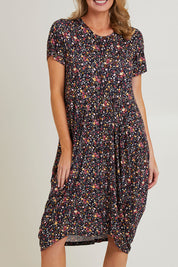 Model Grace wearing size 10 of the Cap Sleeve Bounce Dress in colour Floral (Black), from the front, cropped image
