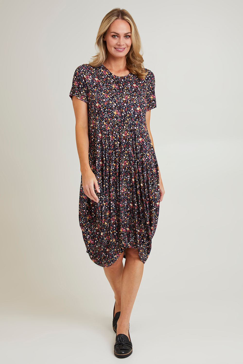 Model Grace wearing size 10 of the Cap Sleeve Bounce Dress in colour Floral (Black), from the front, showing the whole outfit