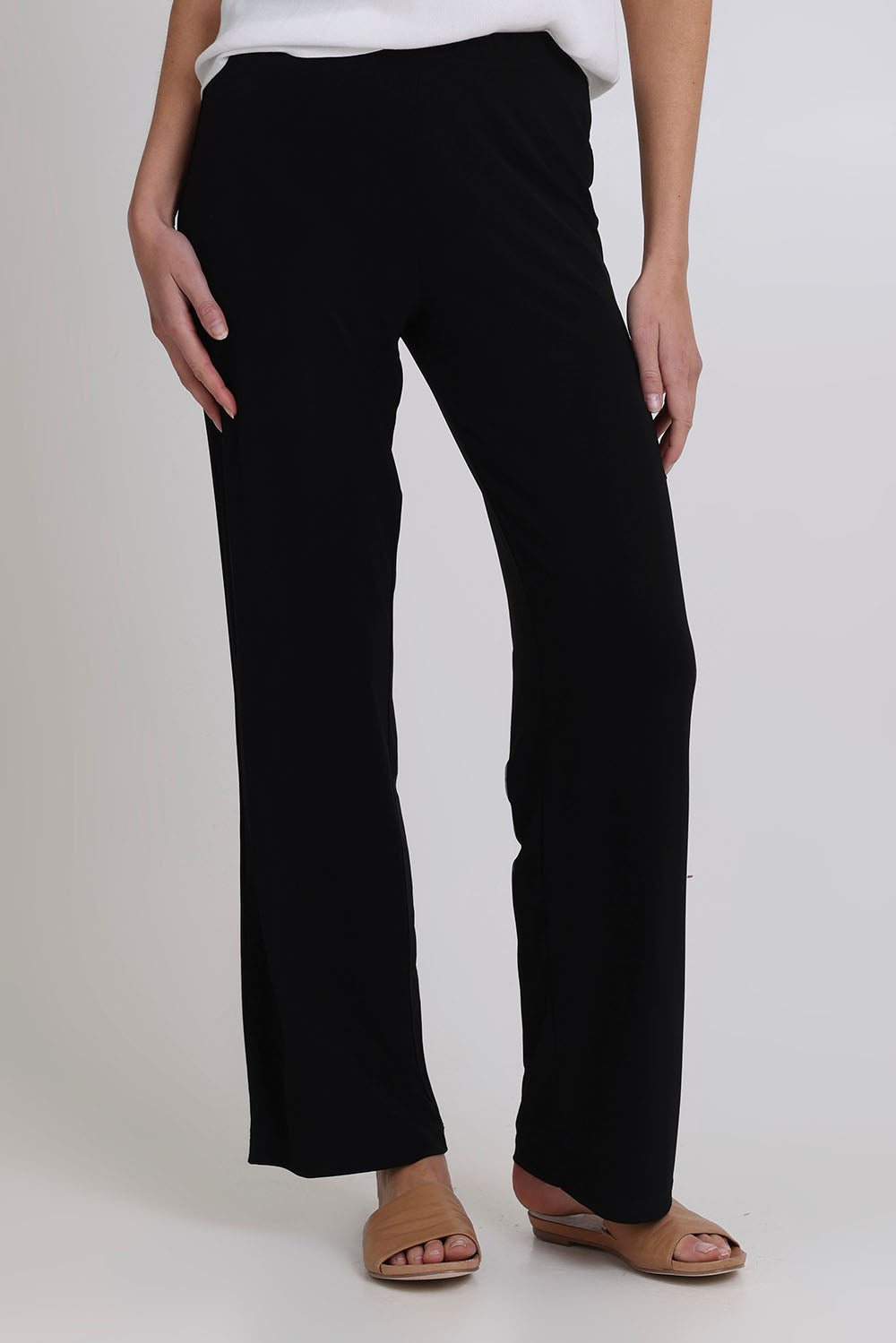 Model Madeline wearing size 10 of the Classic Travel Pant in colour Black (Black), from the front, cropped image