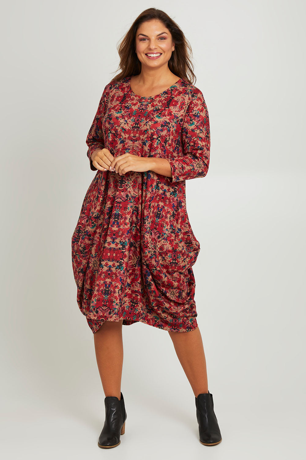Model Monique wearing size 14 of the Bounce Dress in colour Red (Red), from the front, showing the whole outfit
