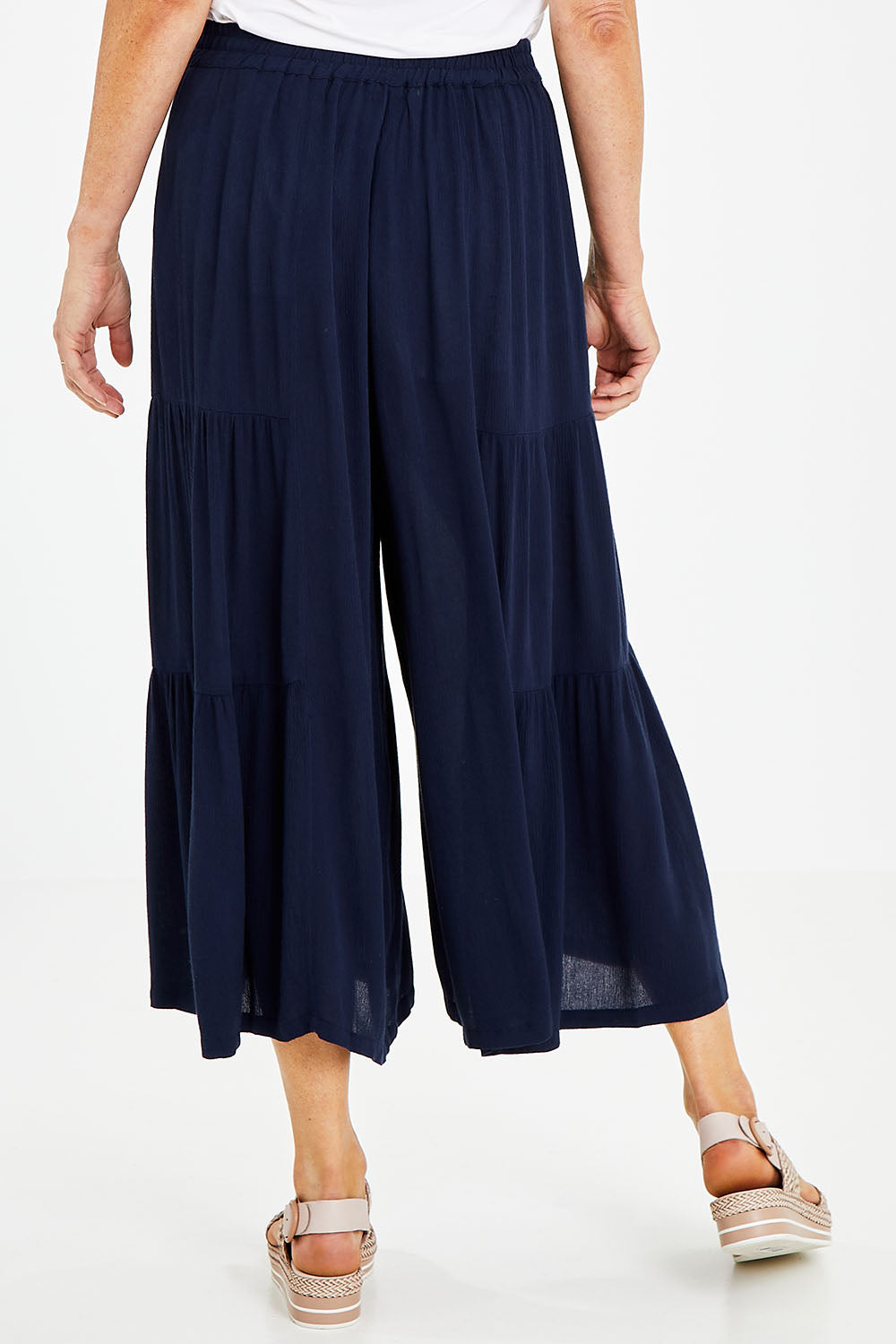Model Naomi wearing size 10 of the Gaucho Pant in colour Navy (Blue), from the back