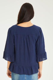 Model Stacey wearing size 10 of the Ruffle Top in colour Navy (Blue), from the back