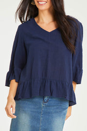 Model Stacey wearing size 10 of the Ruffle Top in colour Navy (Blue), from the front, cropped image