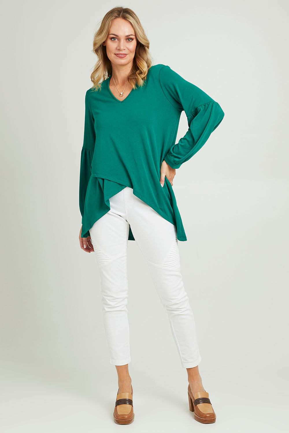Model Grace wearing size 10 of the Hi Lo Knit Tunic in colour Forest (Green), from the front, showing the whole outfit