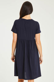 Model Stacey wearing size 10 of the Short Sleeve Holiday Dress in colour Navy (Blue), from the back
