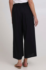 Model Madeline wearing size 10 of the Swinging Pant in colour Black (Black), from the back