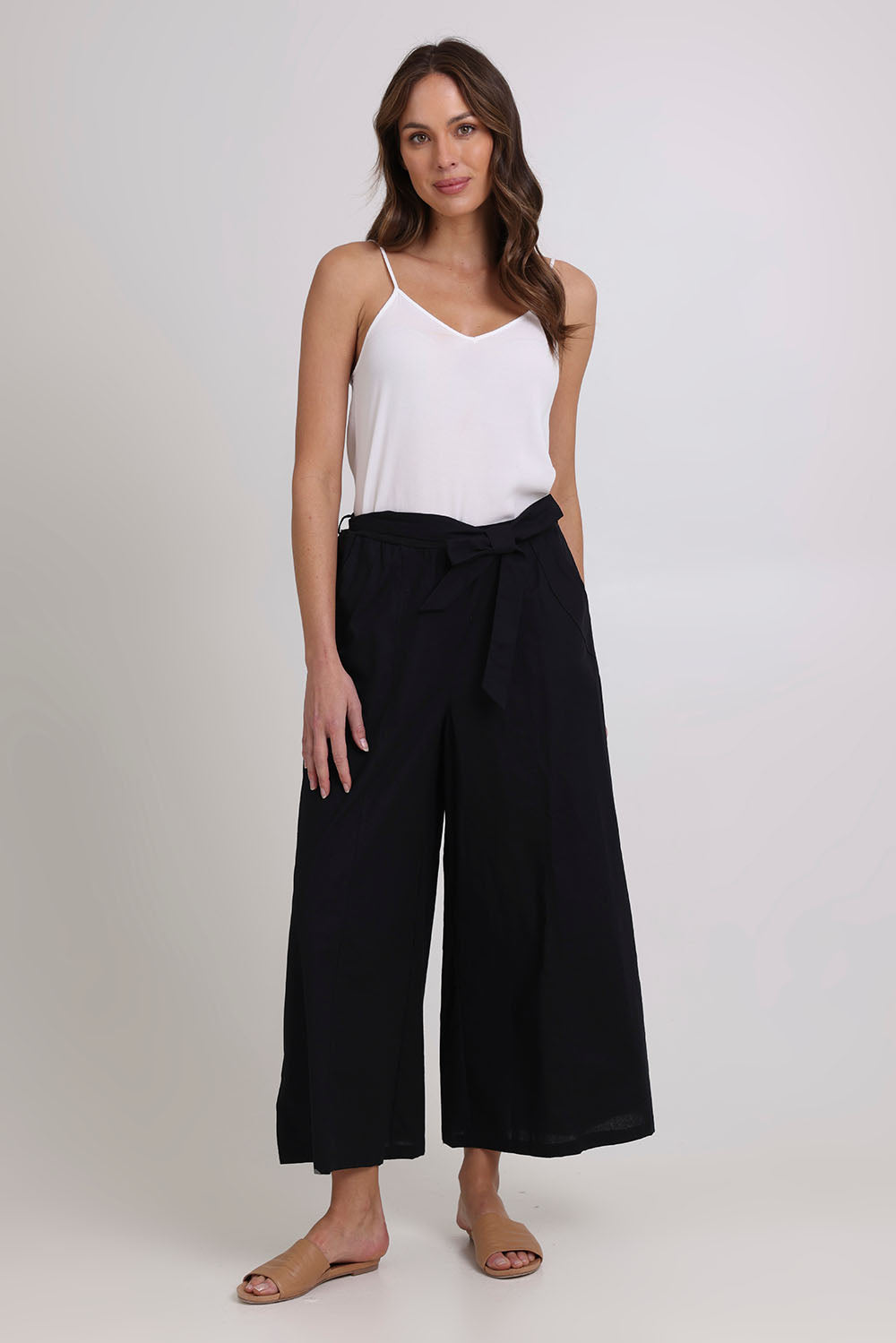 Model Madeline wearing size 10 of the Swinging Pant in colour Black (Black), from the front, showing the whole outfit
