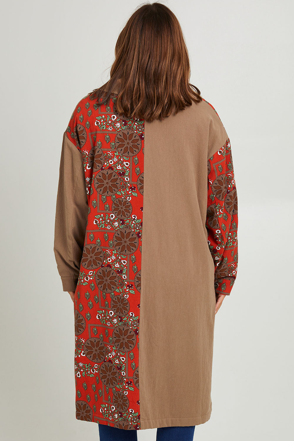 Model Monique wearing size 14 of the Print Splice Coat in colour Rust (Red), from the back
