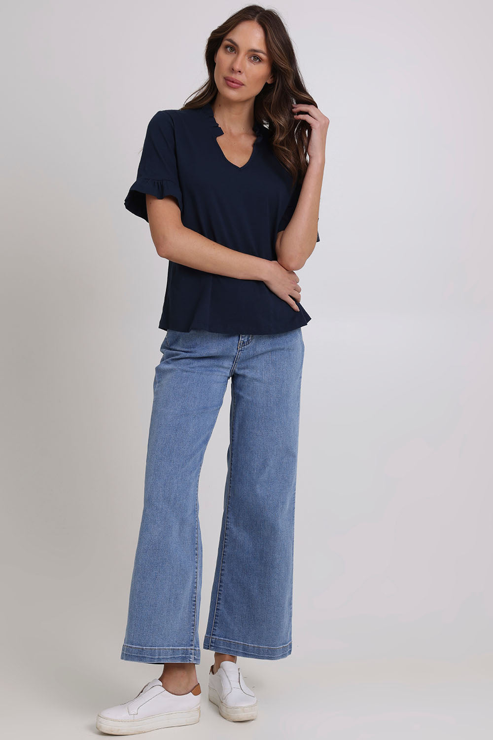 Model Madeline wearing size 10 of the Ruffle Tee Top in colour Navy (Blue), from the front, showing the whole outfit