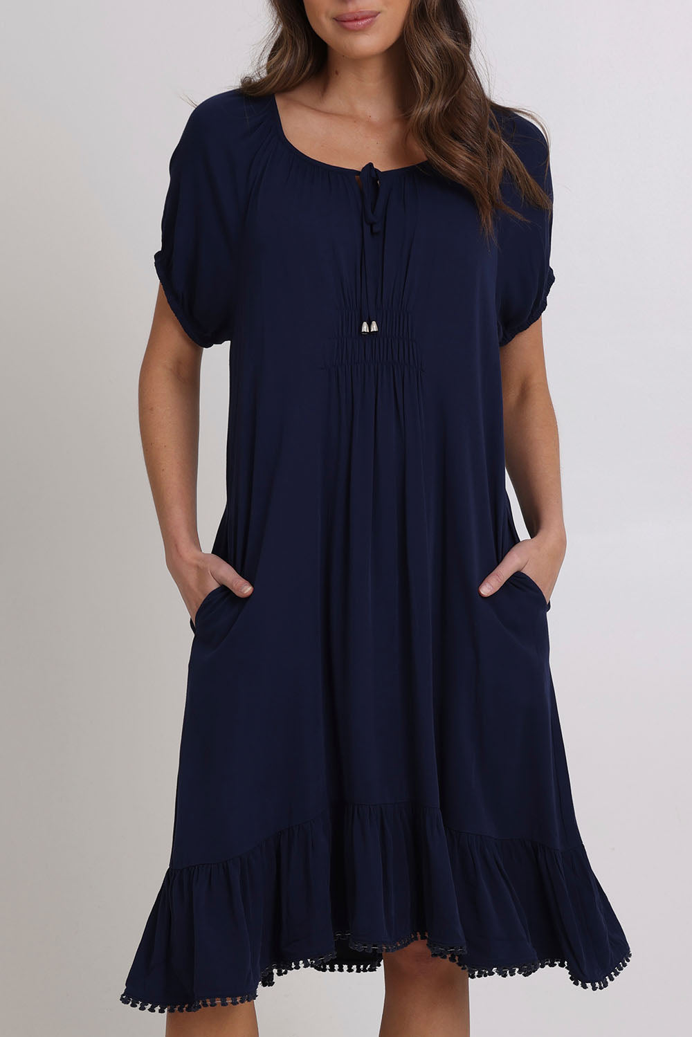 Model Madeline wearing size 10 of the Lucy Core Dress in colour Navy (Blue), from the front, cropped image