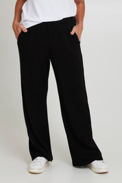 Model Sandy wearing size 10 of the Rachel Rib Pant in colour Black (Black), from the front, cropped image