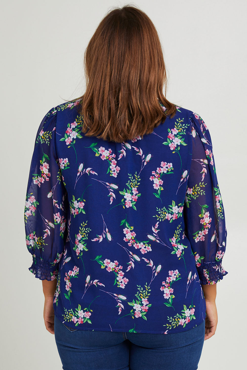 Model Monique wearing size 14 of the Felicity Chiffon Top in colour Blue (Blue), from the back
