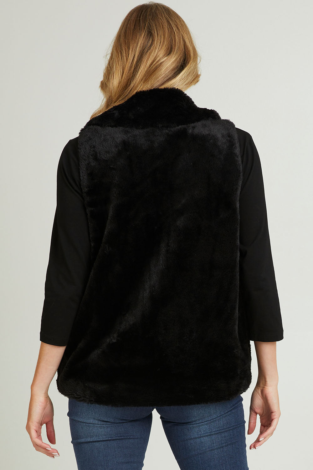 Model Grace wearing size 10 of the Unreal Core Vest in colour Black (Black), from the back