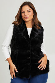 Model Monique wearing size 14 of the Unreal Core Vest in colour Black (Black), from the front, cropped image