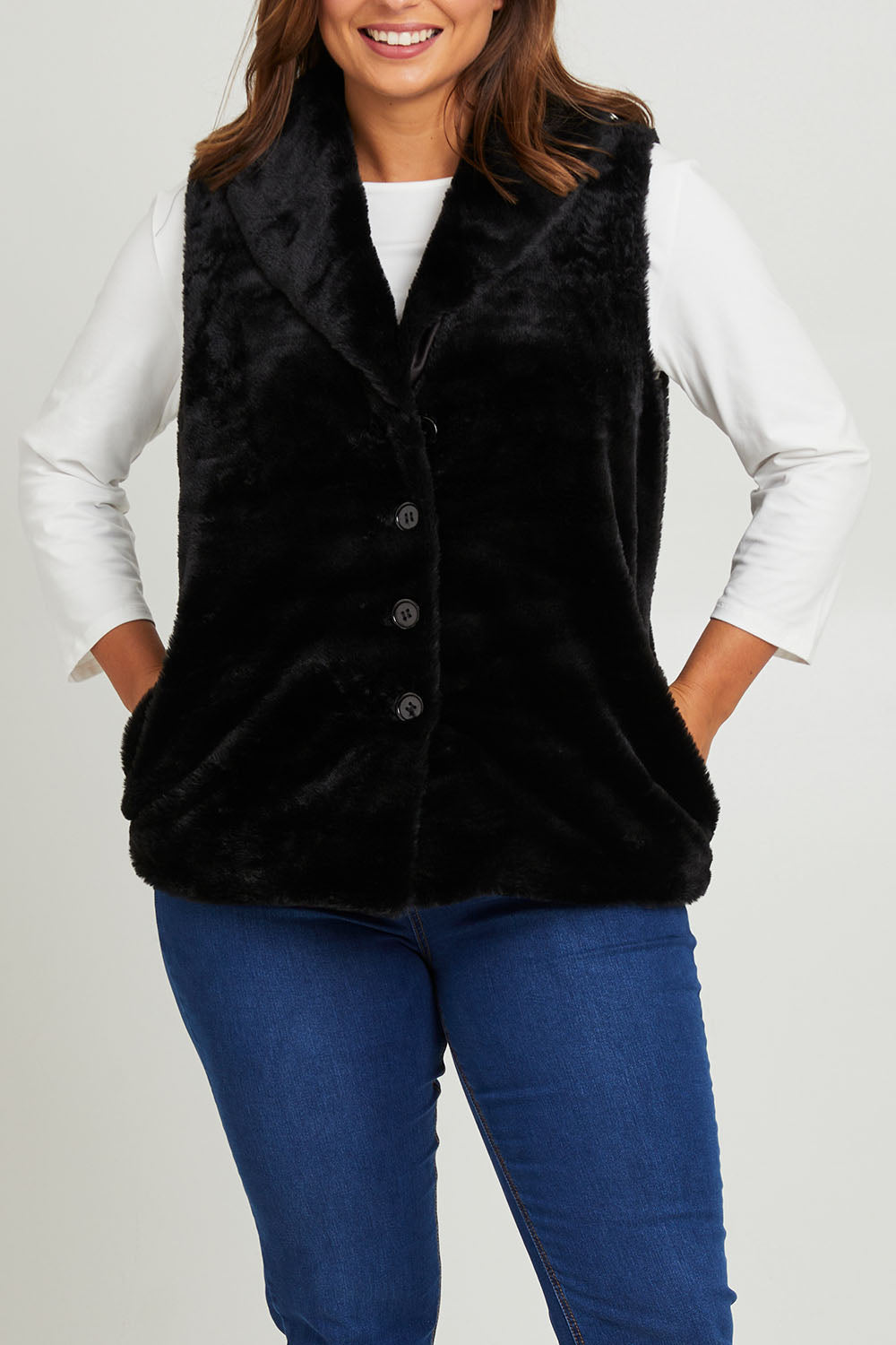 Model Monique wearing size 14 of the Unreal Core Vest in colour Black (Black), from the front, cropped image
