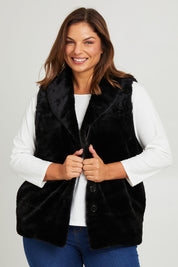 Model Monique wearing size 14 of the Unreal Core Vest in colour Black (Black), from the front, cropped image