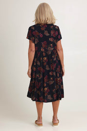 Model Sandy wearing size 10 of The Flounce Dress in colour Navypink (Blue), from the back