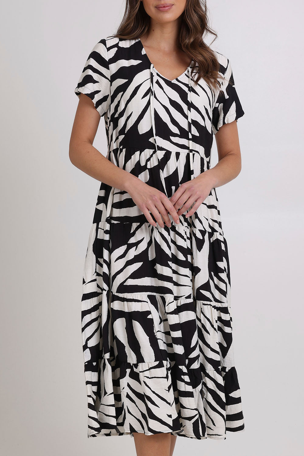 Model Madeline wearing size 10 of the Tier Garden Dress in colour Black (Black), from the front, cropped image