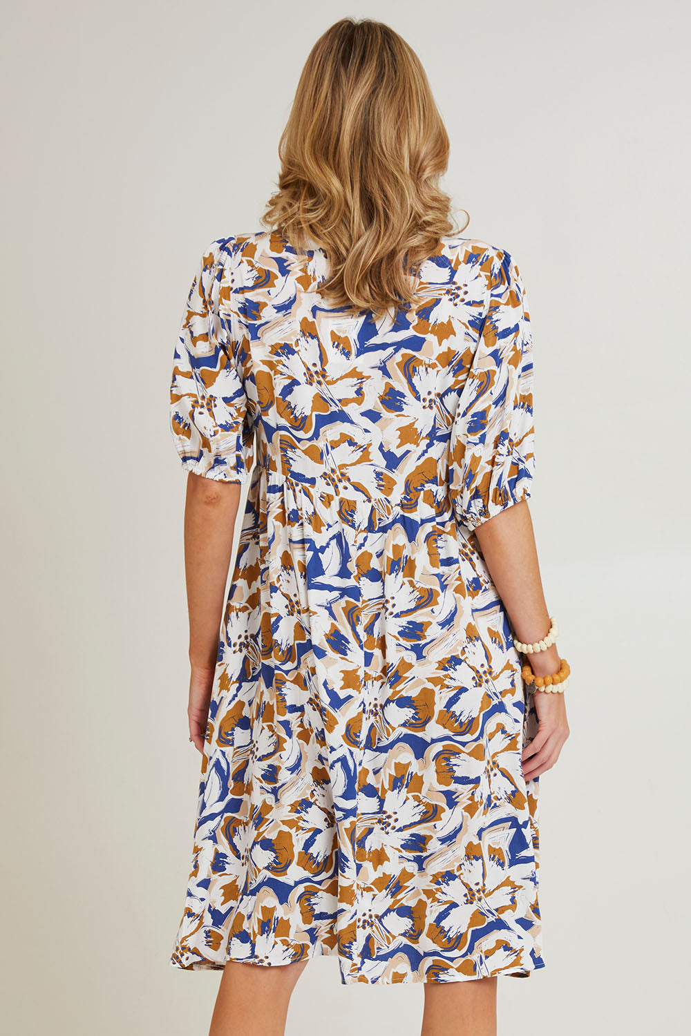 Model Grace wearing size 10 of the Billow Pocket Print Dress in colour Toffee (Blue), from the back