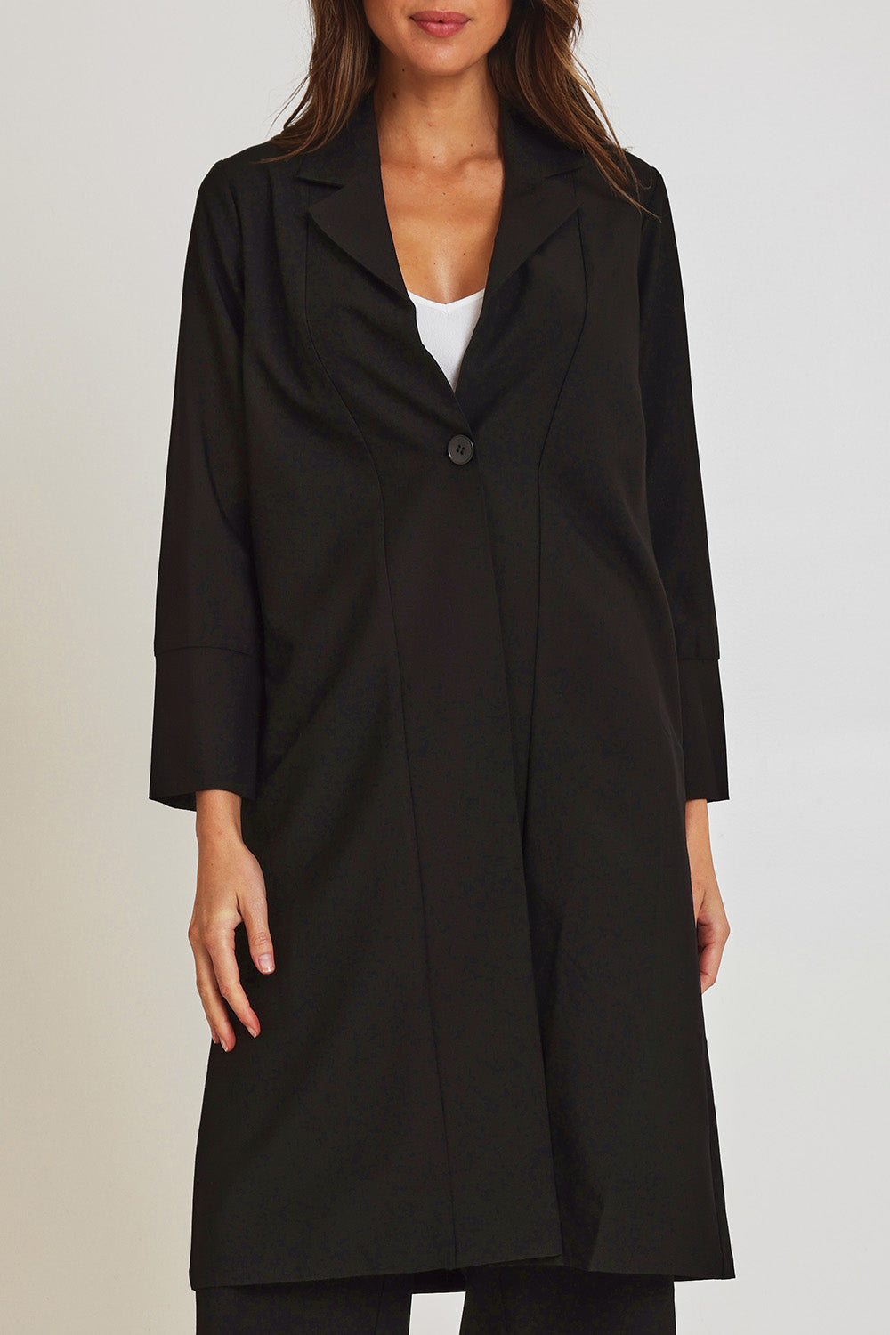 Model Madeline wearing size 10 of the Fluid Longline Jacket in colour Black (Black), from the front, cropped image