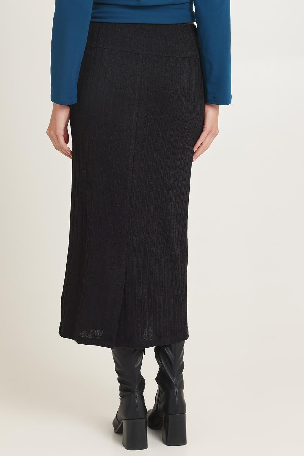 Model Madeline wearing size 10 of the Knit Core Skirt in colour Black (Black), from the back