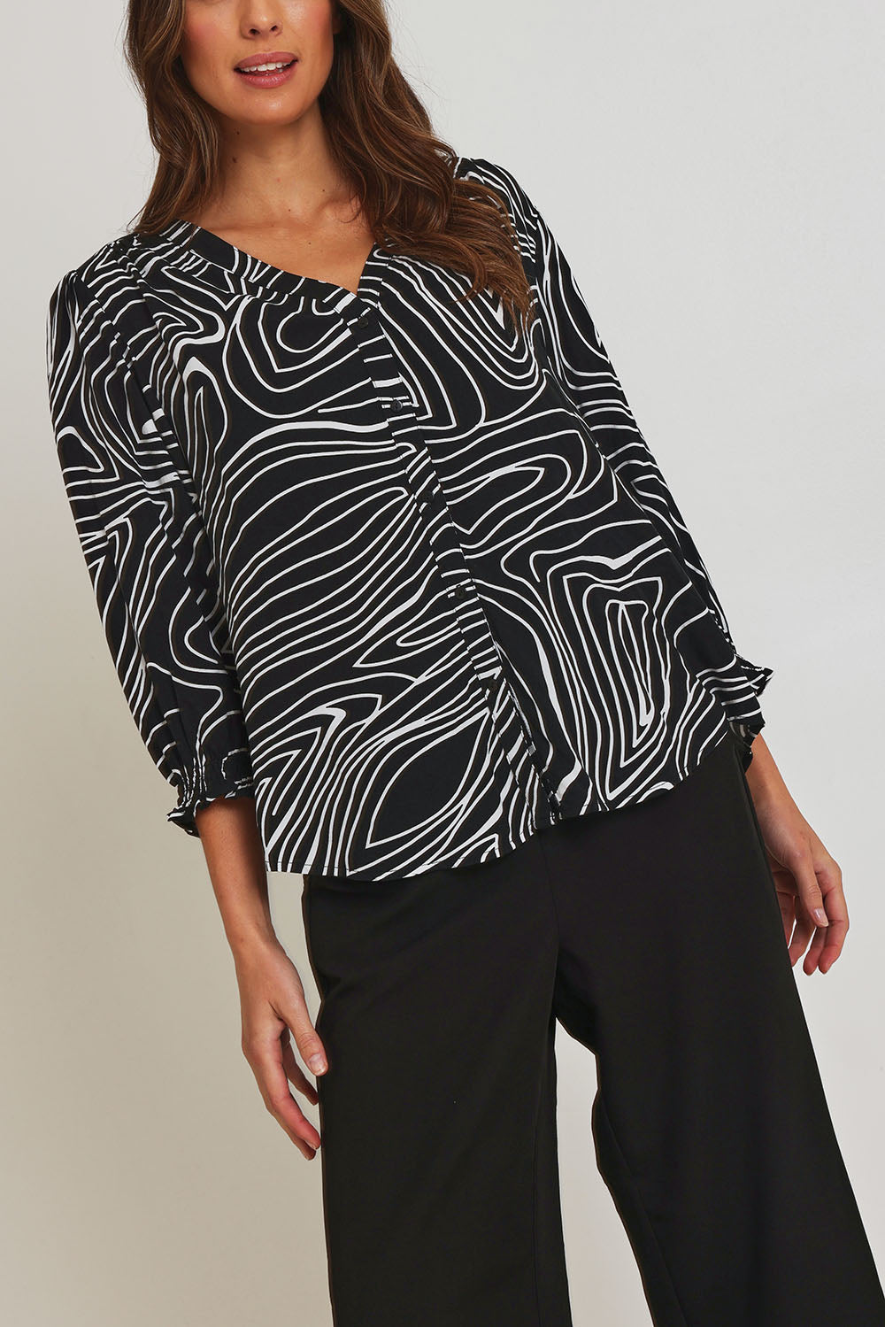 Model Madeline wearing size 10 of the Black And White Button Up Shirt in colour Blackwhite (Black), from the front, cropped image