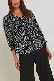Model Madeline wearing size 10 of the Black And White Button Up Shirt in colour Blackwhite (Black), from the front, cropped image