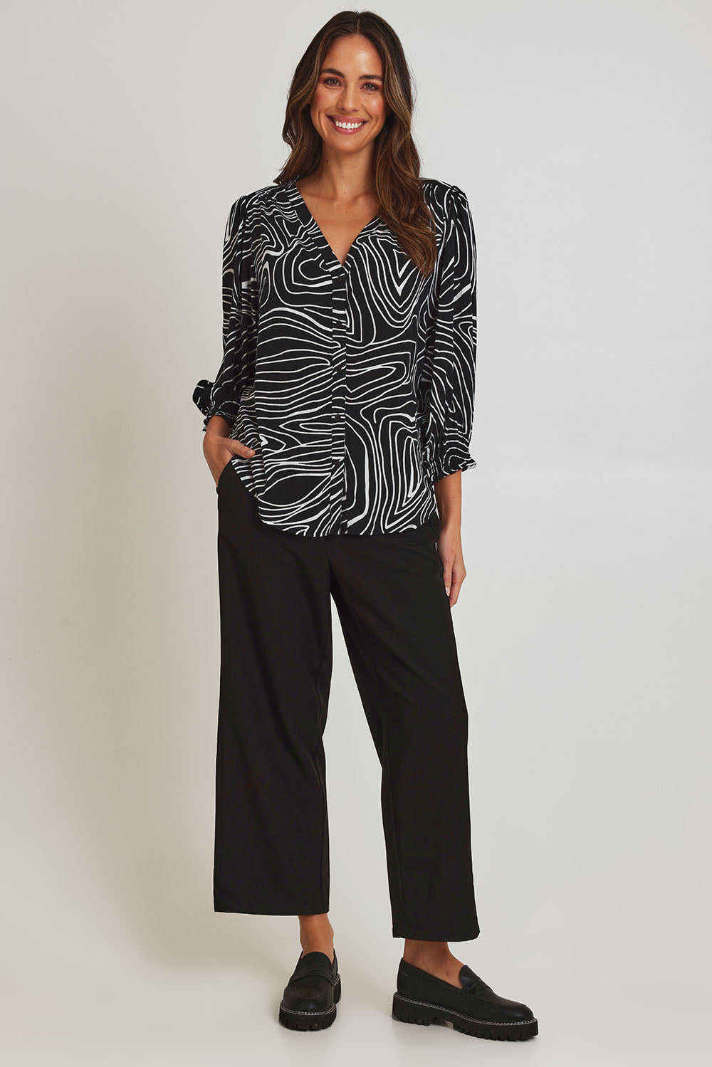 Model Madeline wearing size 10 of the Black And White Button Up Shirt in colour Blackwhite (Black), from the front, showing the whole outfit