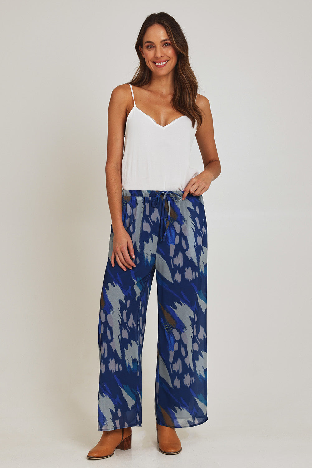 Model Madeline wearing size 10 of the Abstract Pant in colour Blueprint (Blue), from the front, showing the whole outfit