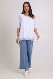 Model Madeline wearing size 10 of the Gilliana Chiffon Overlay Top in colour White (White), from the front, showing the whole outfit
