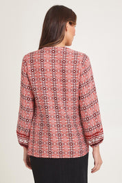 Model Madeline wearing size 10 of the Vera Button Shirt in colour Russet (Red), from the back