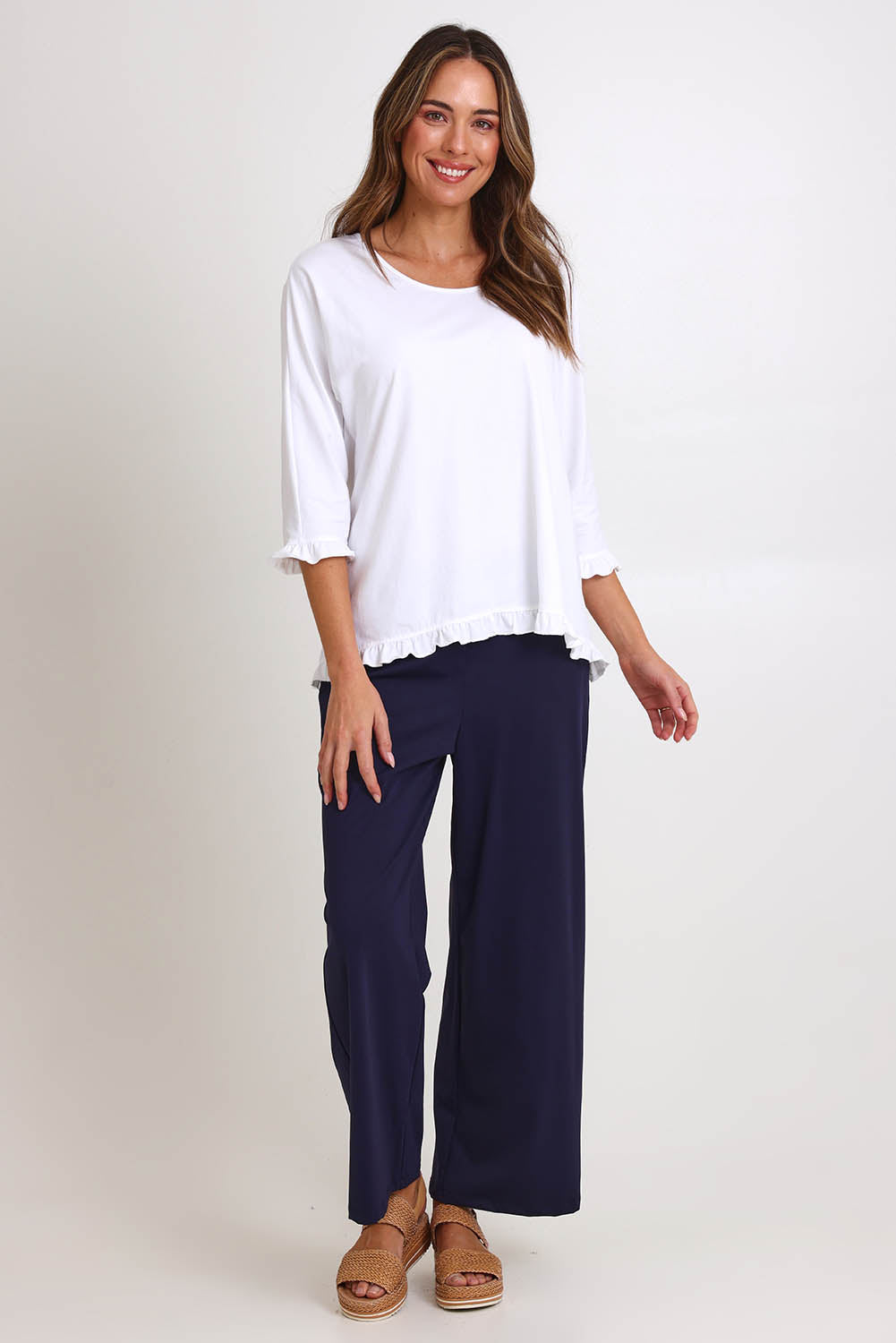 Model Madelinec wearing size 10 of the Ruffle Top – White in colour White, from the front