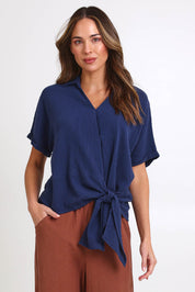 Model Madelinec wearing size 10 of the Core Wrap Over Top – Navy in colour Navy, in a cropped view