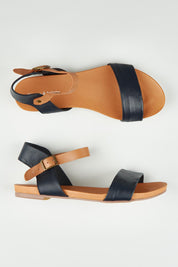 A model wearing size 37 of the Jinnit Leather Flat in colour Navydktan (Blue), from the front, showing the whole outfit
