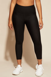 A model wearing the Elite Tight 7/8 in colour Black (Black), from the front, cropped image