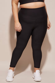 A model wearing the Elite Tight 7/8 in colour Black (Black), from the front, cropped image