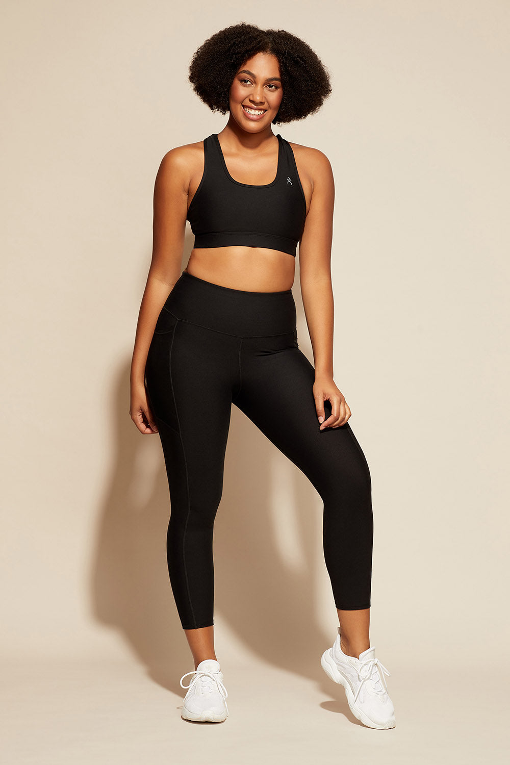A model wearing the Elite Tight 7/8 in colour Black (Black), from the front, showing the whole outfit