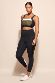 A model wearing the Lay Up Crop in colour Khakiblk (Black), from the front, showing the whole outfit
