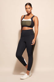 A model wearing the Offense Tight in colour Khakiblk (Black), from the front, showing the whole outfit