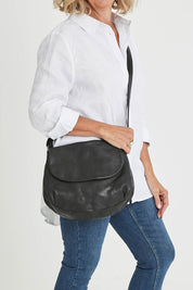 Model Sandy wearing size OneSize of the Grace Leather Bag in colour Black (Black), from the front, cropped image