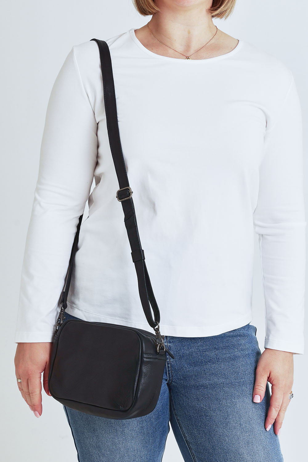 Model Steph wearing size OneSize of the Head In The Clouds Leather Bag in colour Black (Black), from the front, cropped image
