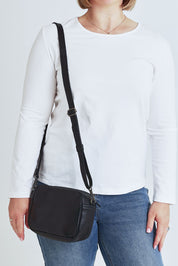 Model Steph wearing size OneSize of the Head In The Clouds Leather Bag in colour Black (Black), from the front, cropped image