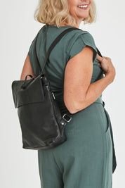 Model Sandy wearing size OneSize of the Neve Leather Backpack in colour Black (Black), from the front, cropped image