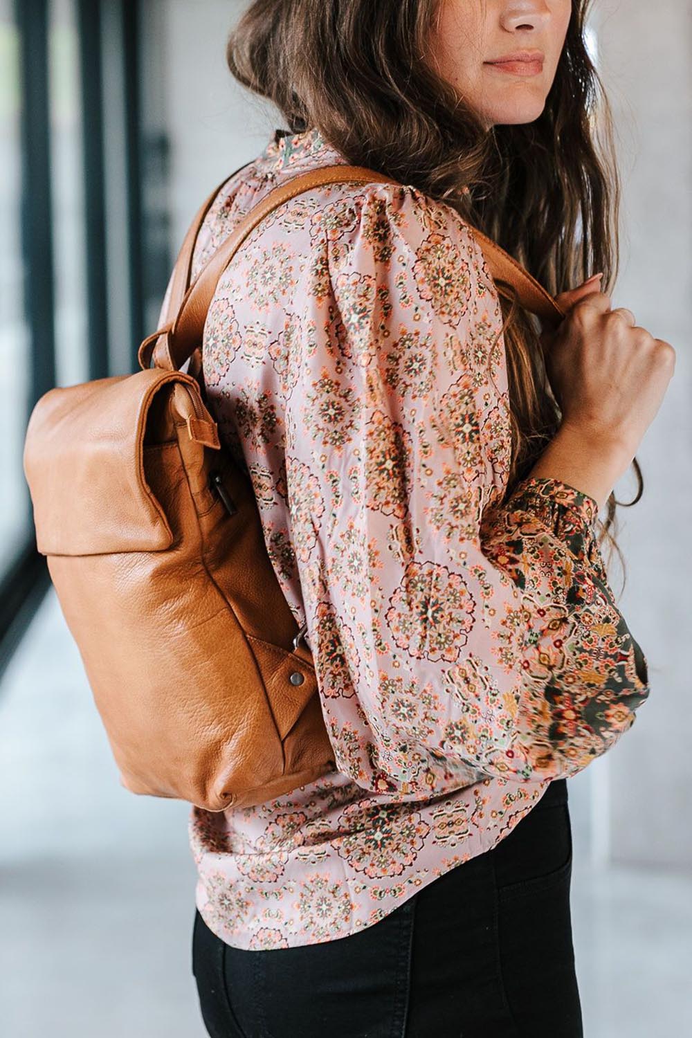 A model wearing the Neve Leather Backpack in colour Tan, from the front, showing the whole outfit